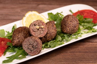 Lübnan restoranında büyük yuvarlak tabakta geleneksel kebbe ve pide ekmeği