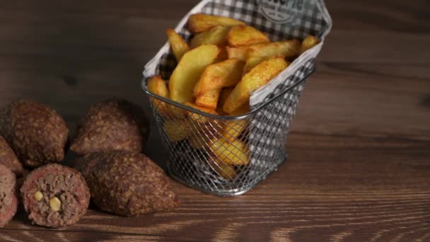 Традиционный кеббе и картофель фри на коричневом столе в ливанском ресторане — стоковое видео