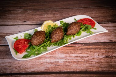 Lübnan restoranında büyük yuvarlak tabakta geleneksel kebbe ve pide ekmeği