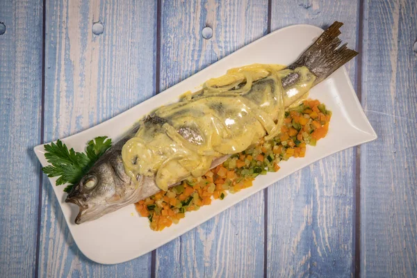 Fish recipe, Baked sea bass with small vegetables and onion sauce, curry, sour cream