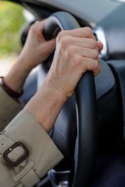 Kadın kıdemli el direksiyon simidi üzerinde