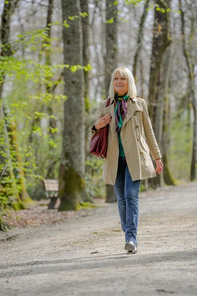 Senior vrouw lopen in een park — Stockfoto