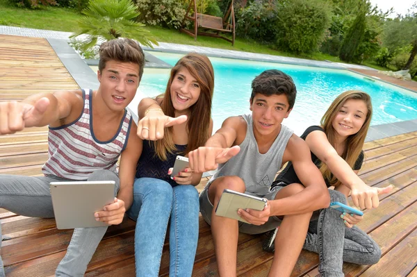 Young teenagers playing on tablet and phone — Stock Photo, Image