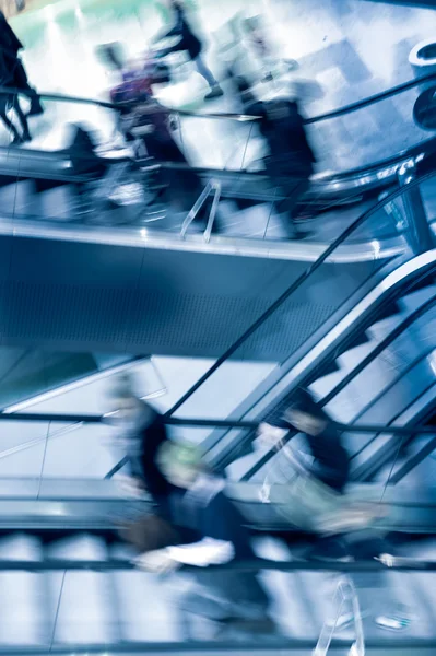 Människor passerar rulltrappor — Stockfoto