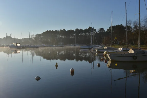 Segelboote bei Sonnenaufgang am See festgemacht — Stockfoto