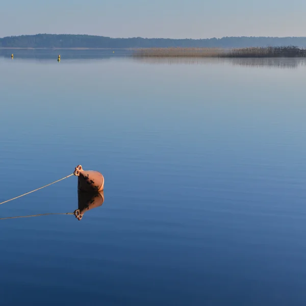 Cumowanie boja na jeziorze w sunrise. — Zdjęcie stockowe