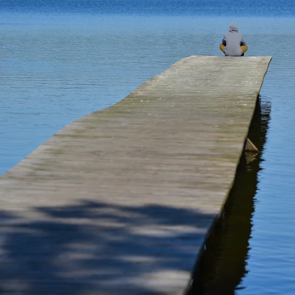 Niño sentado en un lago tirado — Foto de Stock