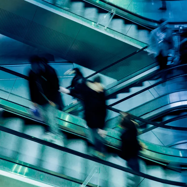 Pessoas em escadas rolantes de cruzamento — Fotografia de Stock