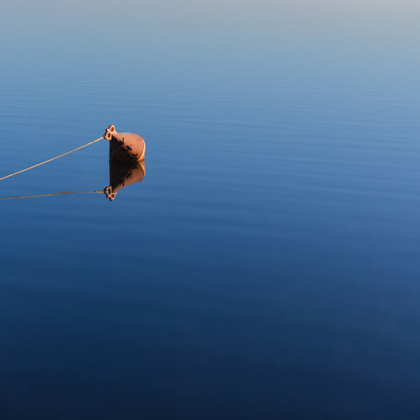 Mooring buoy on a lake at sunrise.