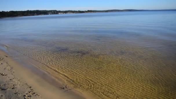 Deserteret sandstrand med bølger rullende ind i godt vejr – Stock-video