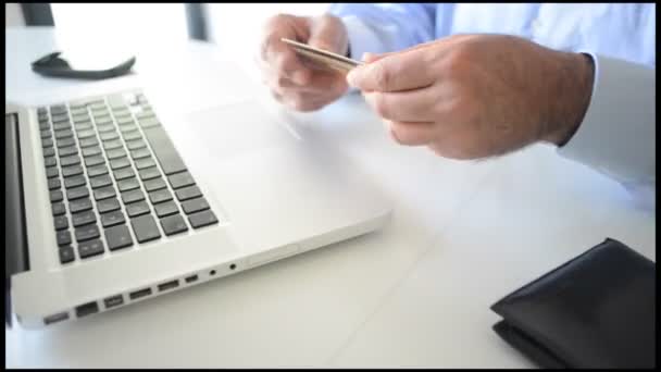 Человек с помощью ноутбука планшетный компьютер и кредитные карты в помещении, покупки в Интернете — стоковое видео