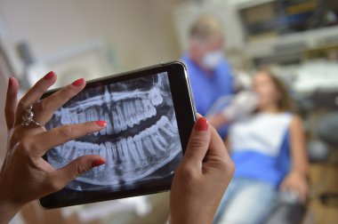 Diş hekimi Office dijital tablet bir hasta x-ışınları ile