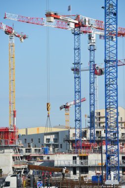 İnşaat vinçleri ve mavi gökyüzü karşı site