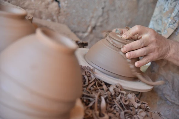 Un artesano marroquí lanza una olla de barro sobre una rueda de alfarero . — Foto de Stock