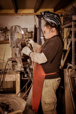 Metal işçisi atölyede duruyor