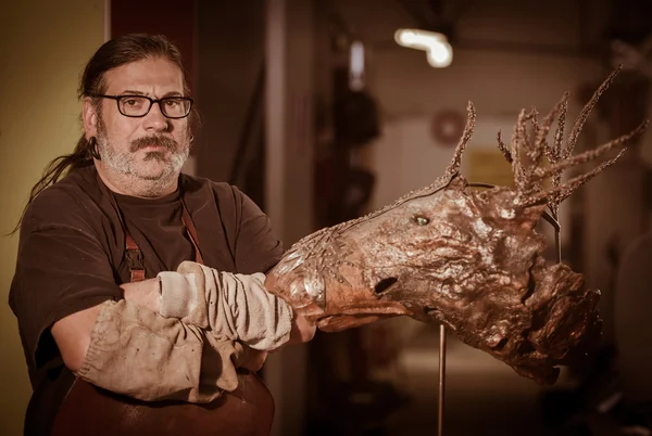 Portrait of a sculptor with one of his works artistic metal — Stock Photo, Image