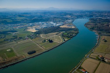 Bu büyüleyici manzara, Adour nehrinin Urt, Landes 'te dolaştığını gösteriyor. Çevresindeki tarım arazileri ve huzurlu evler bölgenin doğal güzelliğini ön plana çıkarıyor, keşifleri teşvik ediyor..