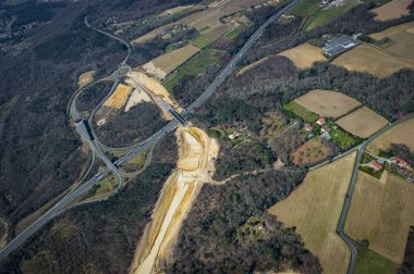 İnşaat ekipleri Fransa 'da yüksek hızlı bir tren hattında çalışarak, bir otoyol paralel giderken arazide bir yol oluşturuyorlar..