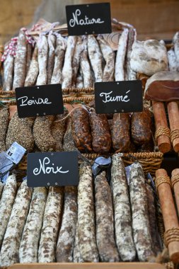 Dordogne, Sarlat 'taki yerel bir markette çeşitli kurutulmuş sosisler sergilendi. Etiketler, yerel mutfak geleneklerini temsil eden Doğa, Noix ve Fume gibi farklı türleri gösteriyor..