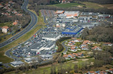 Çeşitli dükkanlar ve otoparklar da dahil olmak üzere hareketli bir alışveriş merkezinin havadan görünüşü.