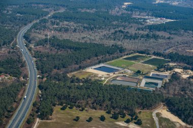 Bereketli yeşil ormanlar yol kenarındaki su arıtma tesislerini çerçeveliyor. Bölgede çok sayıda büyük gölet görülebiliyor ve doğal ortamda sanayi yapıları sergileniyor..
