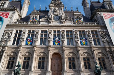 Fransa 'nın çarpıcı Paris Belediye Sarayı' nda karmaşık mimari eserleri sergileniyor. Ön cepheden renkli bayraklar sarkıyor ve tarihi yapıya canlılık katıyor.