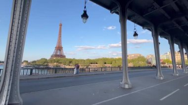 Güneşli bir öğleden sonra boyunca Paris 'teki Eyfel Kulesi manzaralı nehir boyunca yürümenin tadını çıkarıyorum..