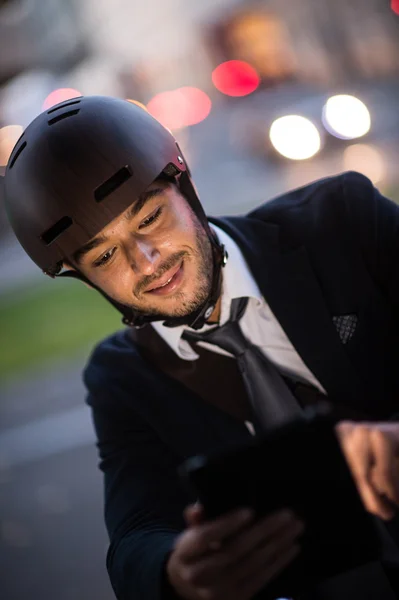 Homme à vélo sur la rue de la ville en utilisant une tablette et une montre intelligente — Photo