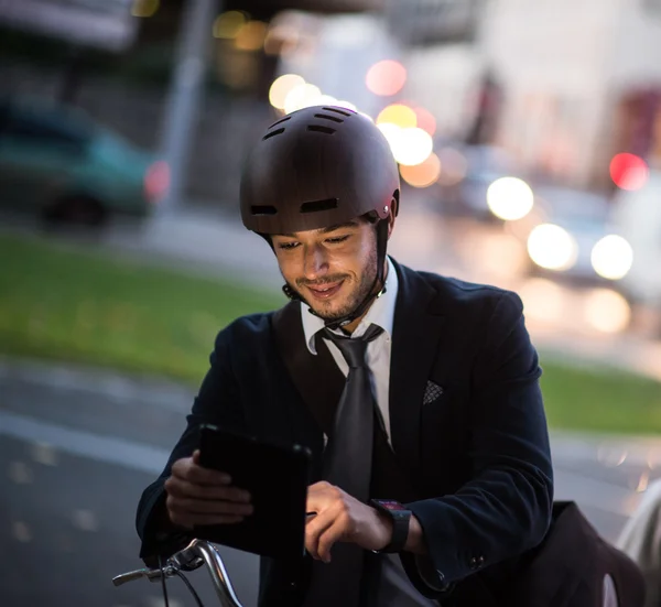 Homme à vélo sur la rue de la ville en utilisant une tablette et une montre intelligente — Photo