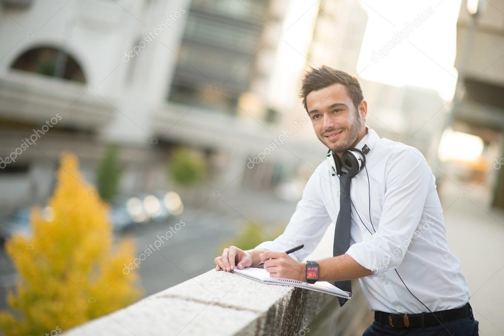 Businessman taking notes on a notebook in the city