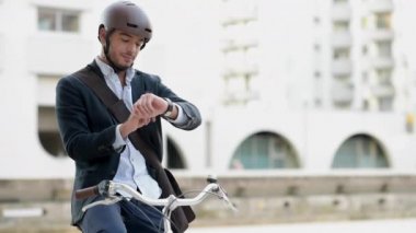 Adam binicilik bisiklet tablet ve akıllı izle kullanarak caddenin üzerinde