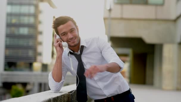 Un hombre usando un teléfono celular con unos audífonos divertidos — Vídeos de Stock