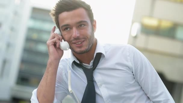 Un uomo che usa un cellulare con una cuffia divertente — Video Stock