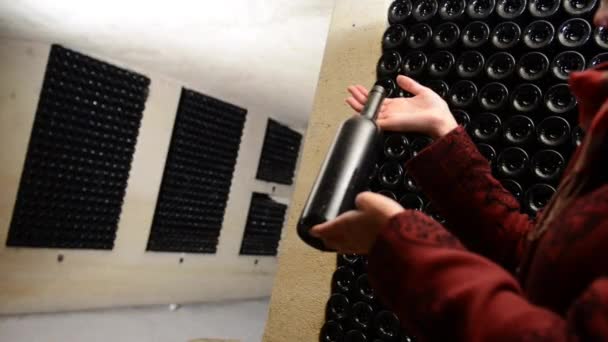 A women holds a bottle of wine in an aging cellar.Bordeaux Wineyard — Stock Video