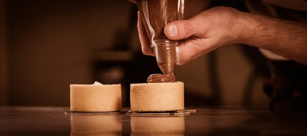 Konditorei in seiner Werkstatt bereitet Schokoladenkuchen zu — Stockfoto