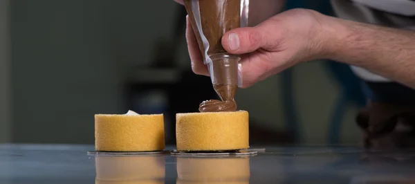 Konditorei in seiner Werkstatt bereitet Schokoladenkuchen zu — Stockfoto