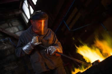 Koruyucu giysi fırın bir Endüstr içinde yan yatan çelik işçisi