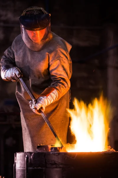 Lavoratore siderurgico in un forno per la rastrellatura di indumenti protettivi in un'industria — Foto Stock