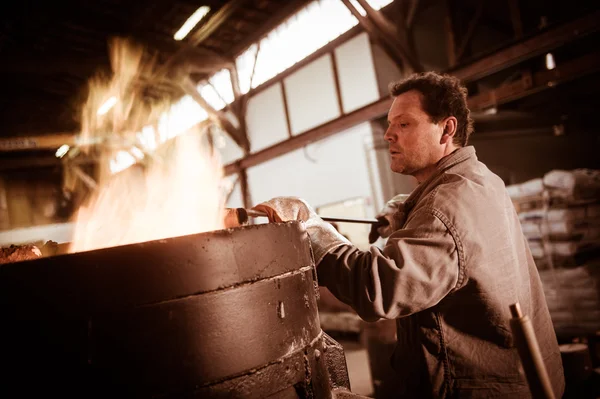 Stahlarbeiter in Schutzkleidung rechen Ofen in einer Industrieanlage — Stockfoto