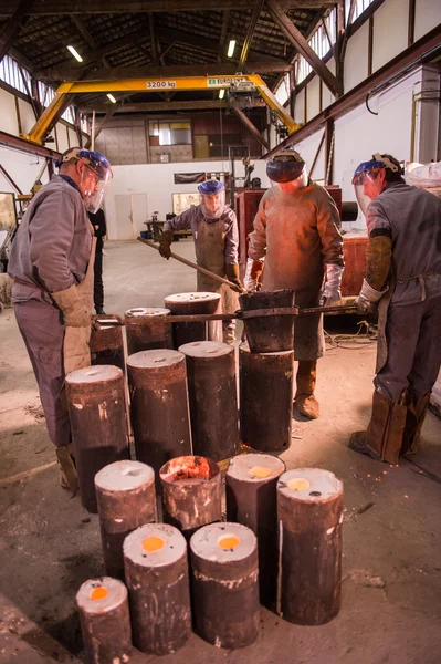 Ocelové pracovník v ochranné oděvy hrabání pece v průmyslové — Stock fotografie