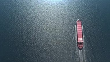 Uçak, deniz havası, nakliye ve ithalat konseptiyle Boş Kargo gemisinin üzerinden uçuyor. Konteynır gemisi ve uçak, kargoyu okyanusu aşıyor. Ulaşım. Teslimat. Lojistik, yukarıdan aşağı görünüm