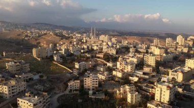 Filistin Kasabası al-Eizariya 'da cami, Kudüs' e yakın hava manzarası ve Maale adumim Şehri, gün batımı, Musevi çölü, Aralık 2020