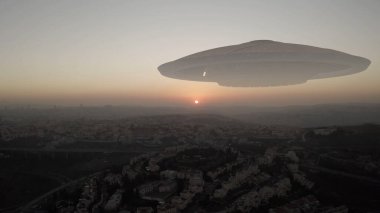 Uzaylı uzay gemisi Ufo gün batımında şehrin üzerinde süzülüyor. Hava görüntüsü, İsrail 'deki Kudüs şehri üzerinde görsel efekt unsuru, istila bilimkurgu konsepti.