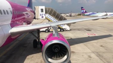 wizz air plane on Israel airport before take off, ben gurion airport, purple wing and boarding stairs plane