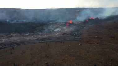 People standing close to active volcano aerial view, Mount Fagradalsfjall, Iceland4K drone shot from Iceland of Hot lava and magma coming out of the crater, April 2021 