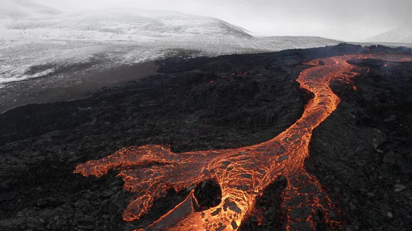 lava eruption volcano with snowy mountains, Aerial viewHot lava and magma coming out of the crater, April 2021