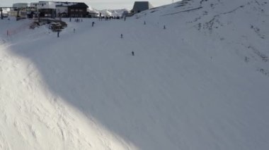 Kayak merkezindeki kayak yapan insanların hava görüntüsü. İHA tepeden aşağıya, Alp dağlarından aşağıya, Dolomitler İtalya 'ya uçuyor.