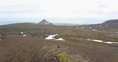 İzlanda 'nın açık arazisinde yürüyen yalnız bir yürüyüşçü, İzlanda' nın kayalık tarlaları ve dağları için hava aracı manzarası