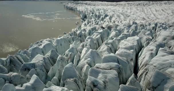 ヨーロッパの氷河ラグーンの上の空中ビュー黒い灰とFjallsrlnアイスランドの尾根 氷を溶かす 地球温暖化の概念2021年2月 — ストック動画