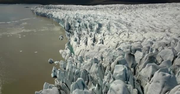 ヨーロッパの氷河ラグーンの上の空中ビュー黒い灰とFjallsrlnアイスランドの尾根 氷を溶かす 地球温暖化の概念2021年2月 — ストック動画
